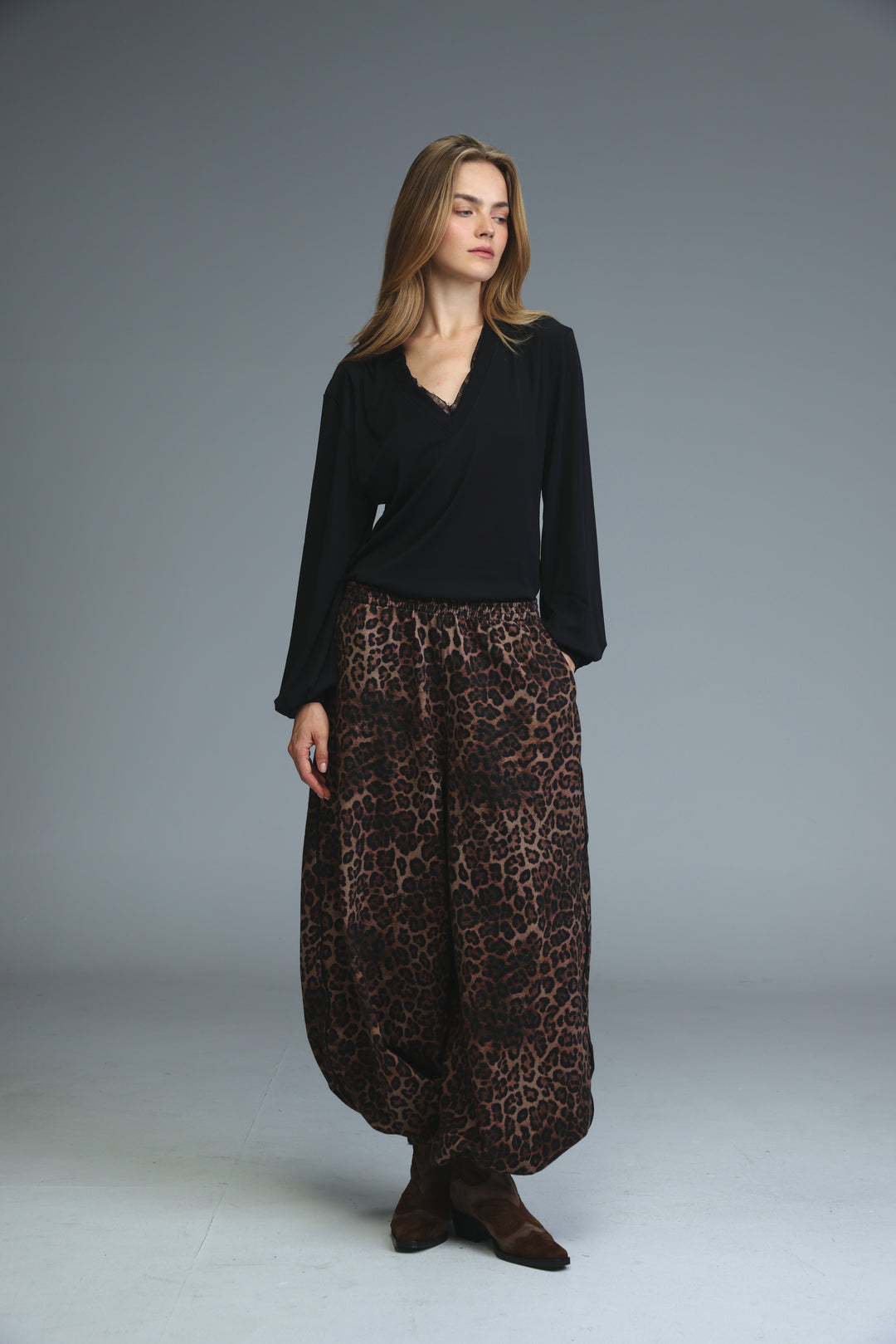 Marry black shirt paired with flowing wide-leg leopard-print pants in rich brown and black tones front view