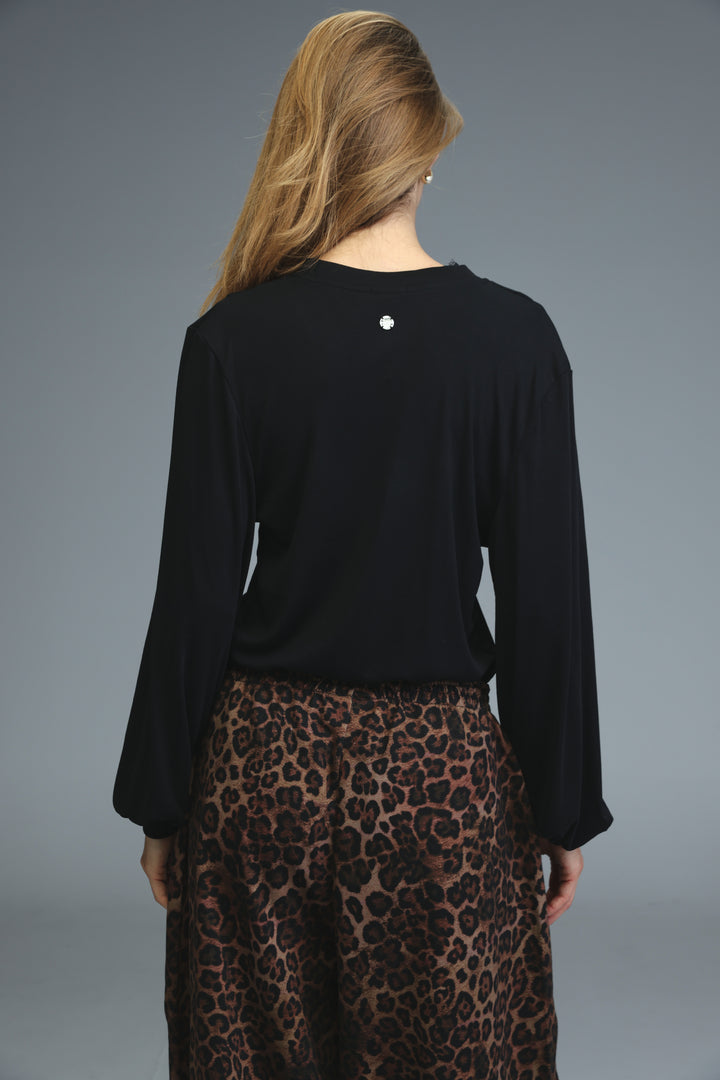 Black long-sleeved marry shirt with a subtle silver emblem at the neckline shown from the front