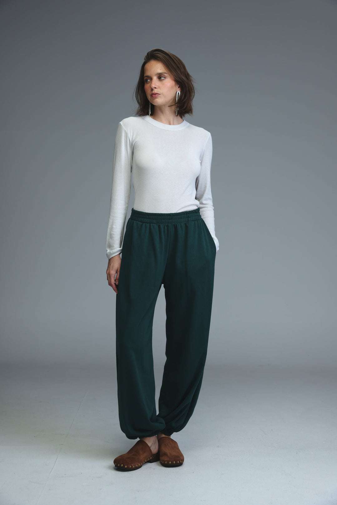Dark green loose-fitting joggers with elastic waist and soft fabric texture shown from the front view