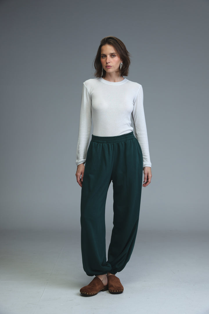 Dark green joggers with elastic waist and loose fit shown from the front featuring a soft fabric texture