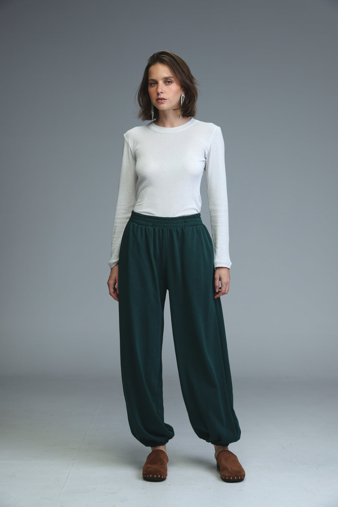 Dark green loose-fitting joggers with elastic waist and cuffed ankles shown from the front