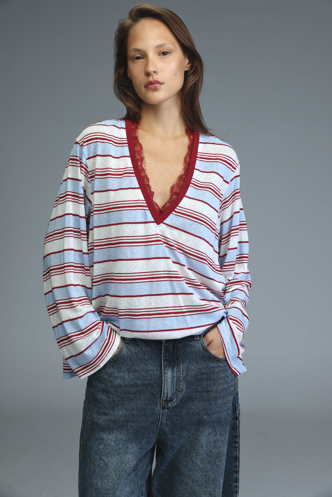 A glow red striped long-sleeved v-neck shirt with horizontal stripes and lace trim along the neckline