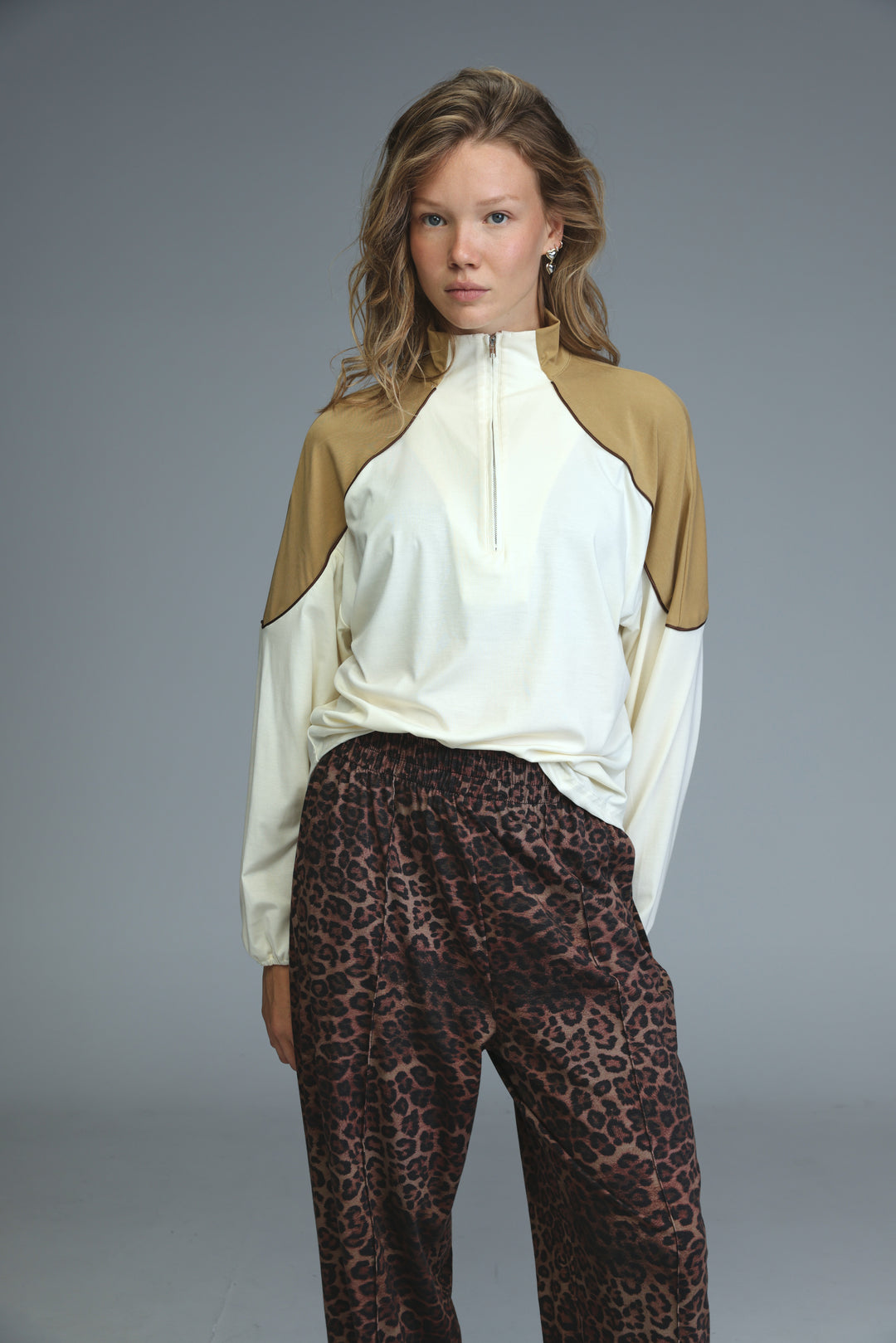 Allure cream sweatshirt cream and tan color-blocked zip-up top with sleek modern design shown from front