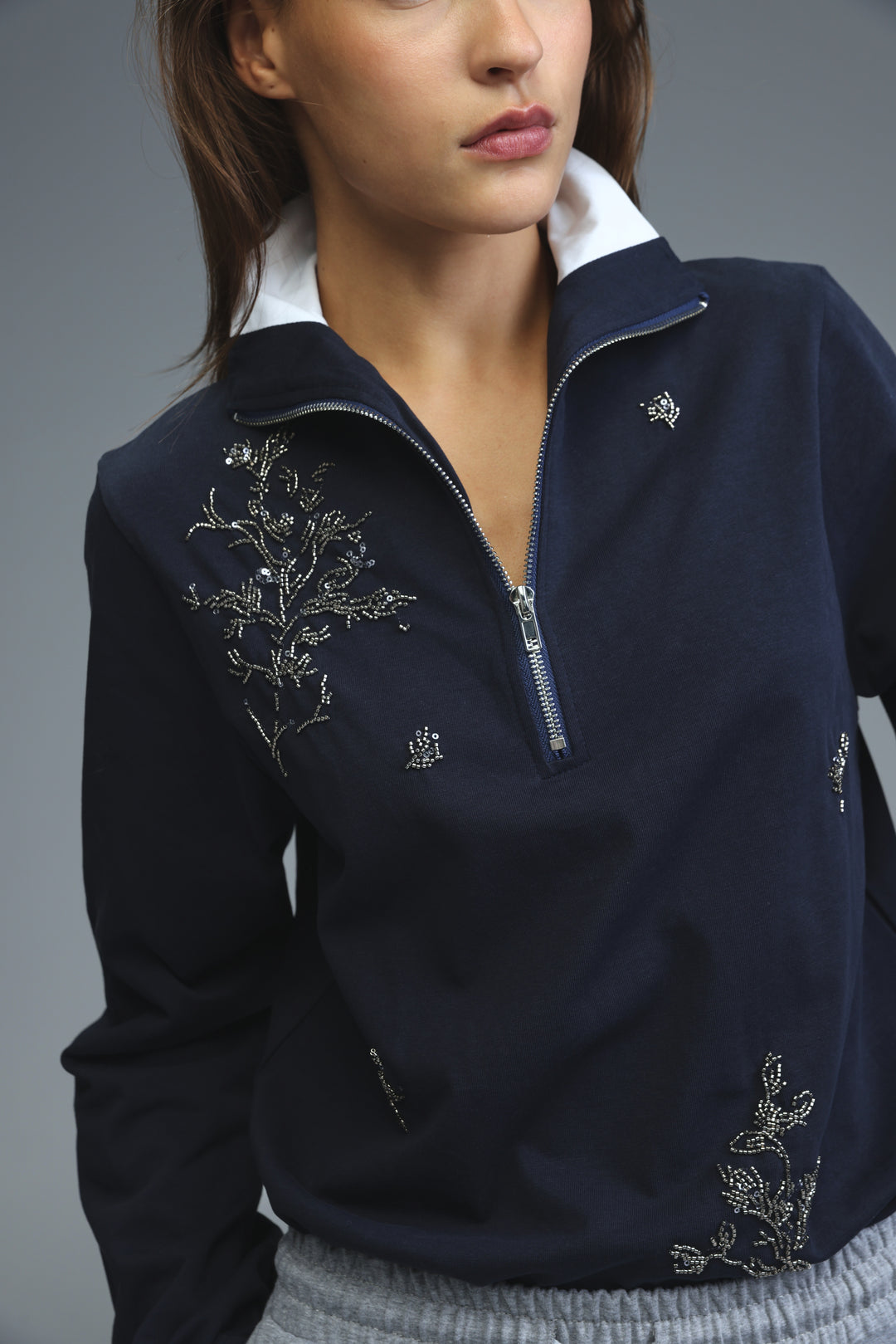 Navy blue zip-up jacket with silver beaded floral embroidery and white collar front view titled Joy Navy Polo