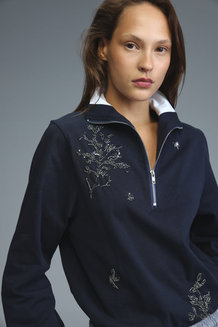 Navy blue zip-up sweater with silver floral embroidery on chest and sleeves shown from front view