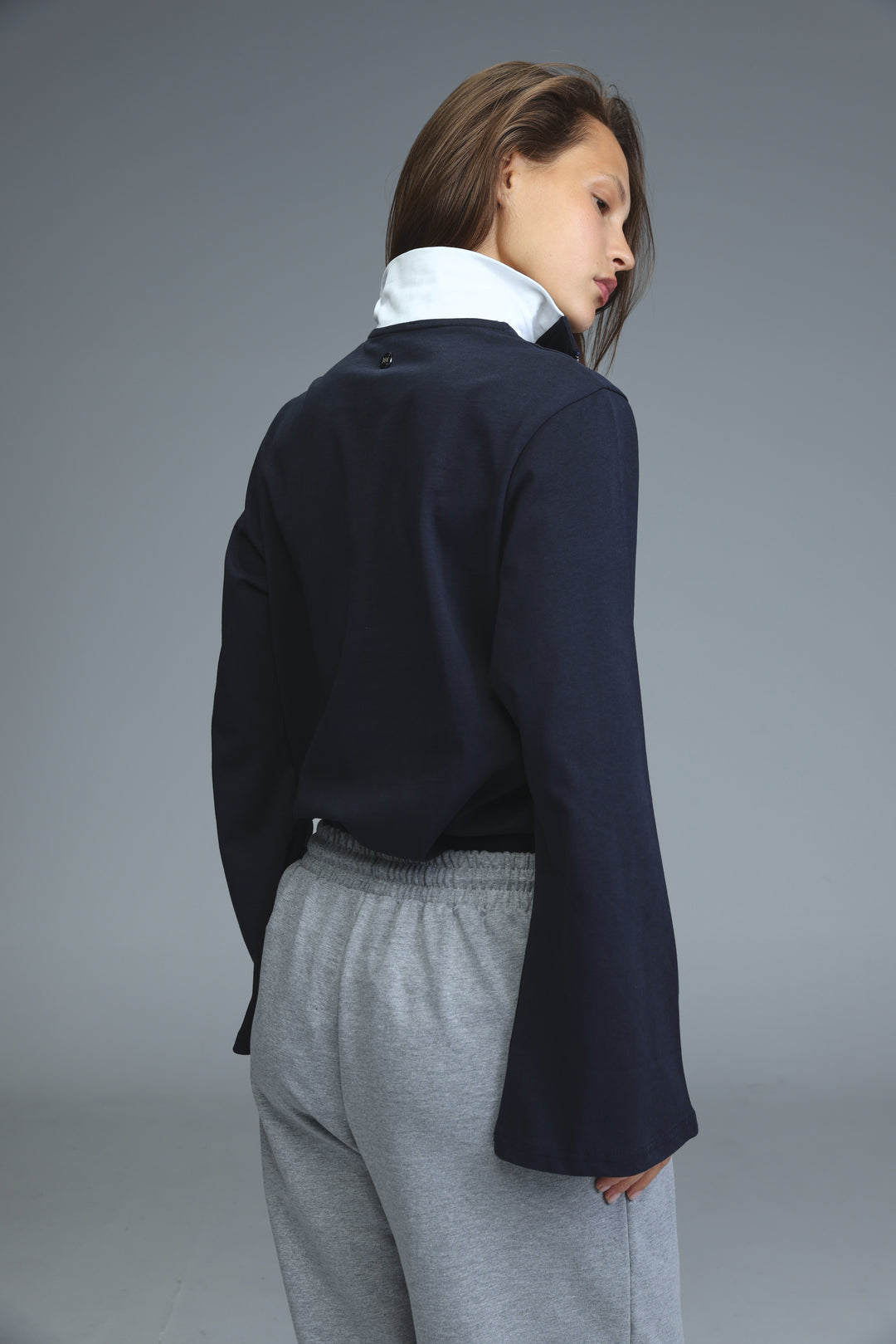 Navy blue cropped blazer with bell sleeves worn over a white collared shirt front view titled Joy Navy Polo