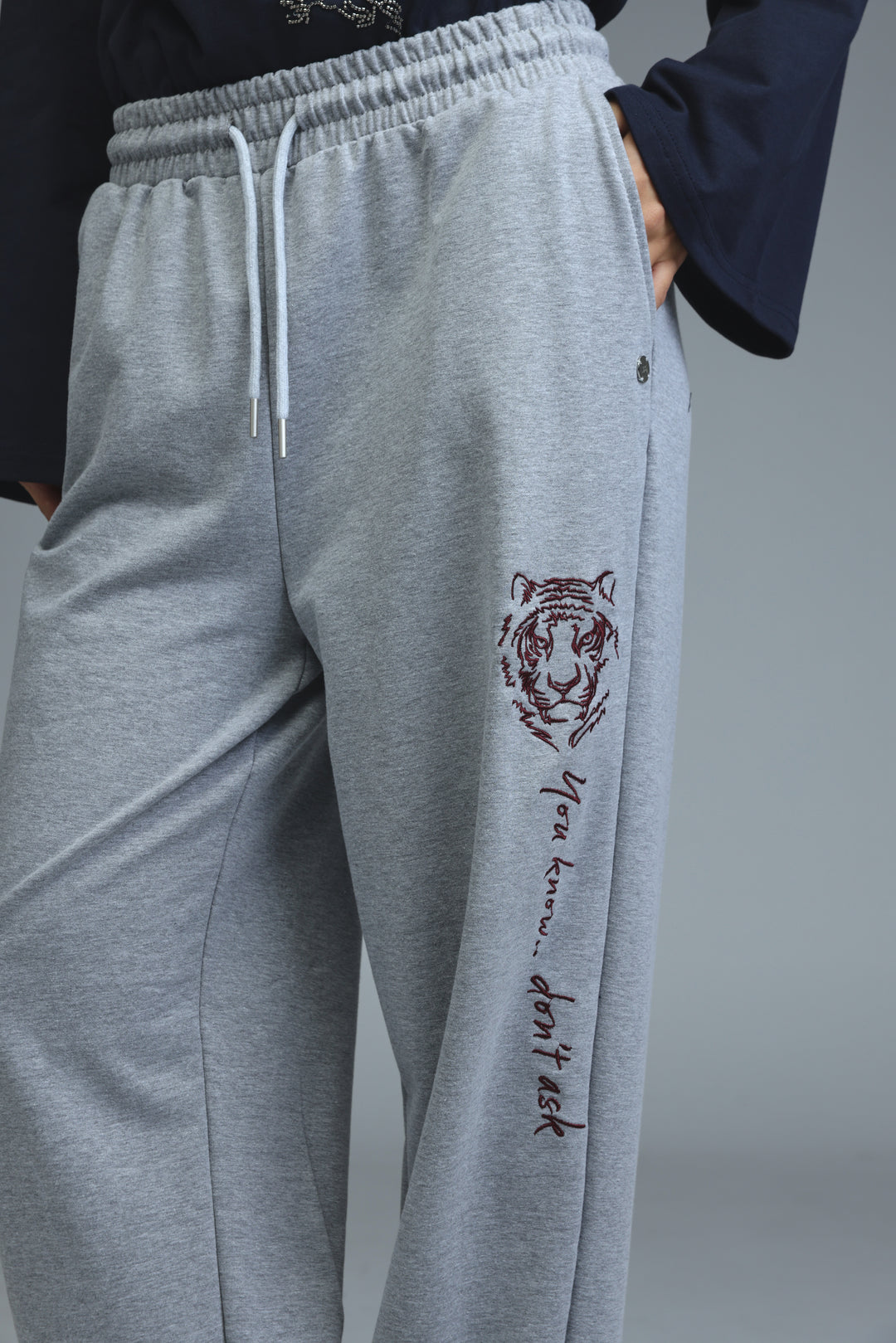 Iconic grey joggers with gray tiger-themed embroidered design and drawstring waistband shown from the front