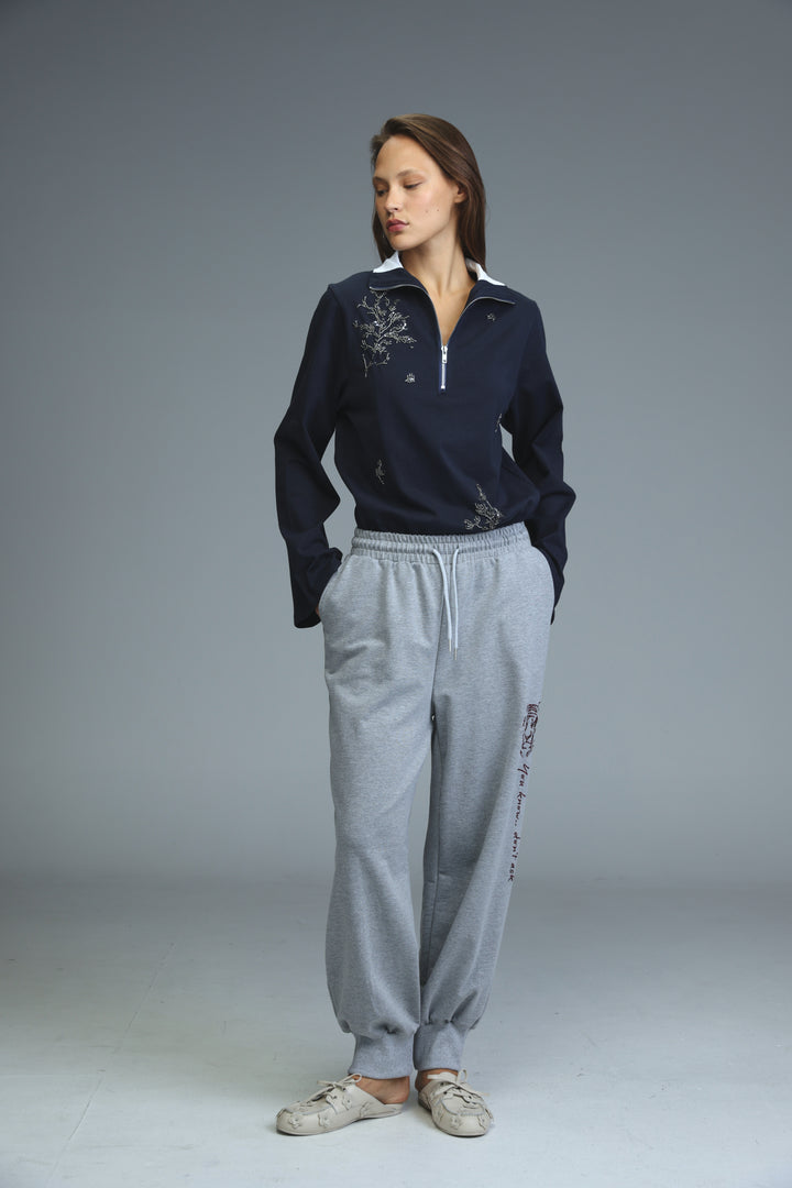 Navy blue zip-front sweatshirt with white collar and silver embroidery on the chest shown from the front