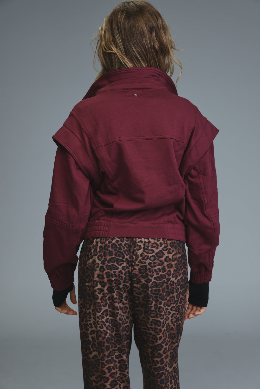 Maroon puzzle wine jacket with a high collar and ruffled sleeves shown from the front