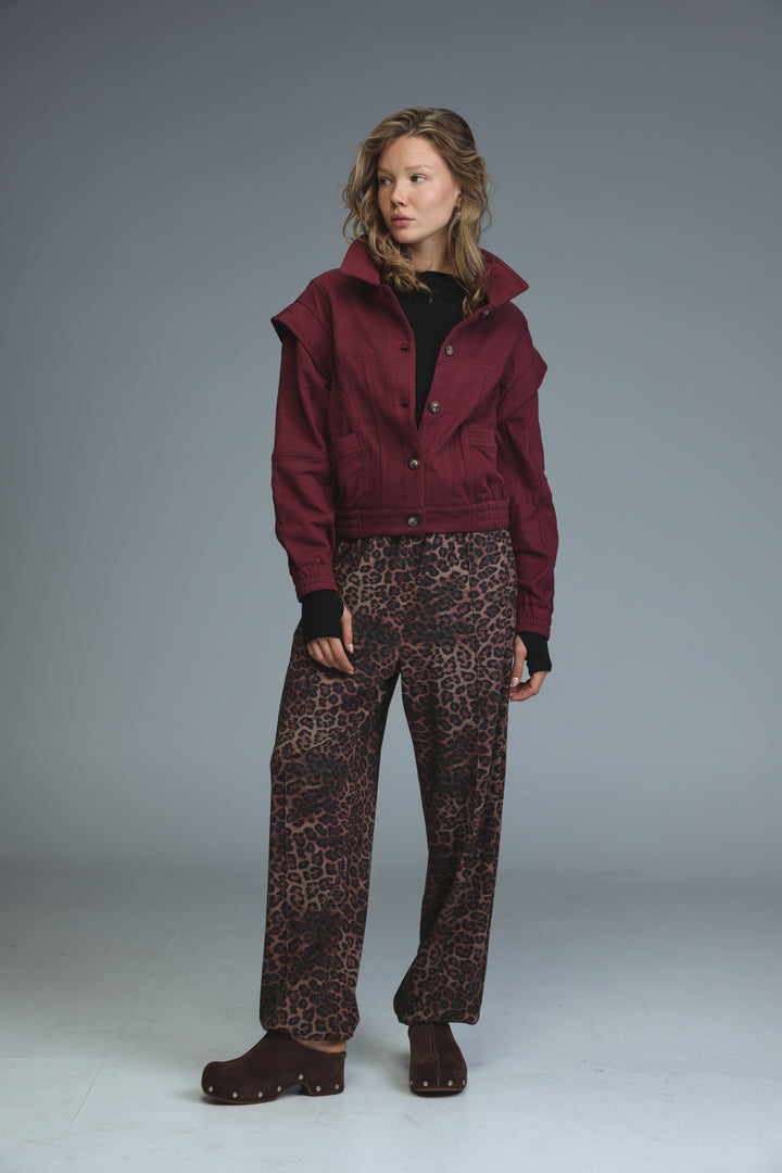 Maroon cropped puzzle wine jacket with high collar and button closures shown from the front