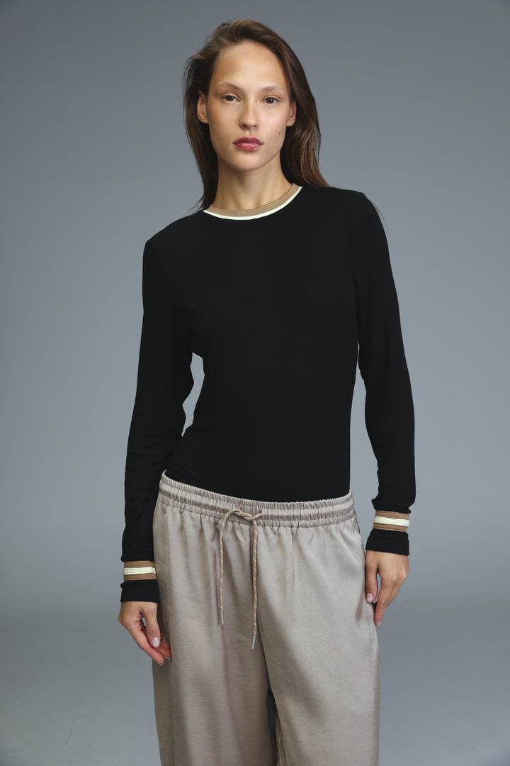Black long-sleeved bodysuit with cream-colored ribbed trim at neckline and cuffs shown from the front