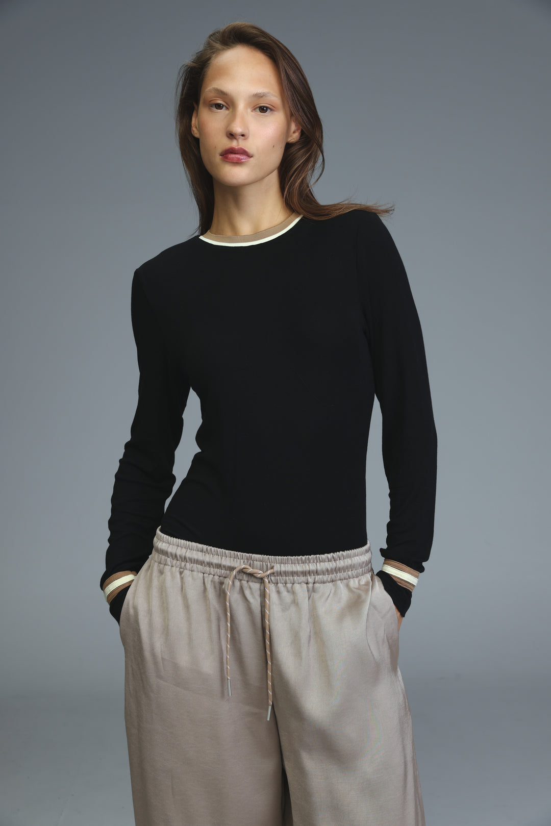 Black trim bodysuit with long sleeves and white trim at neckline and cuffs shown from the front