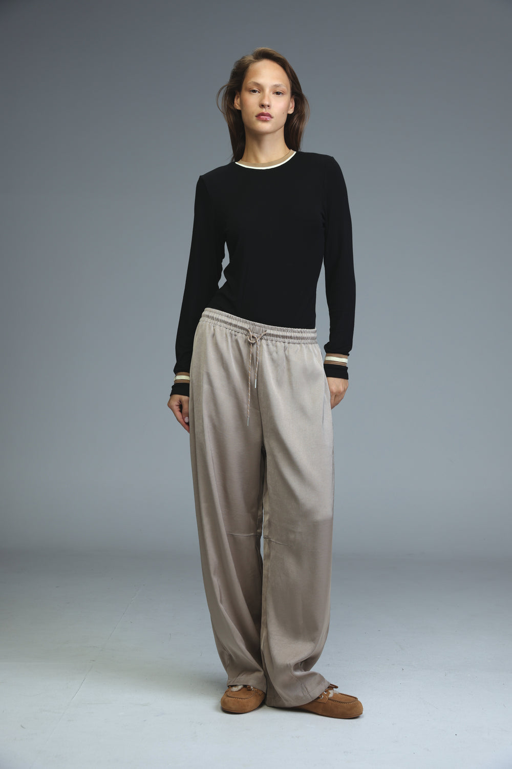 Black long-sleeved bodysuit with white ribbed crew neckline and matching striped cuffs, front view