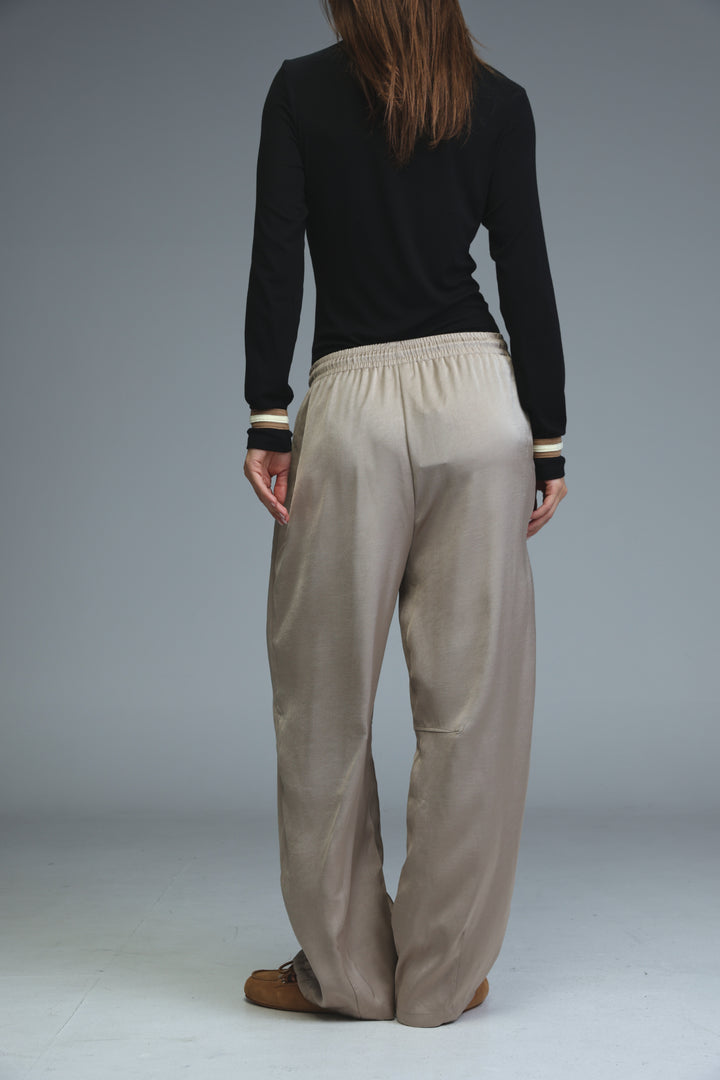 Golden camel wide-leg trousers with elastic waistband and subtle ribbed cuffs shown from the front