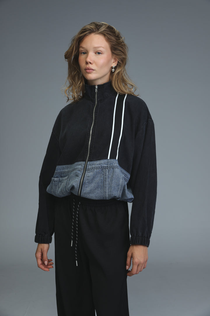 Black and blue denim patchwork track jacket with white zipper trim shown from front in soft denim panel jacket design