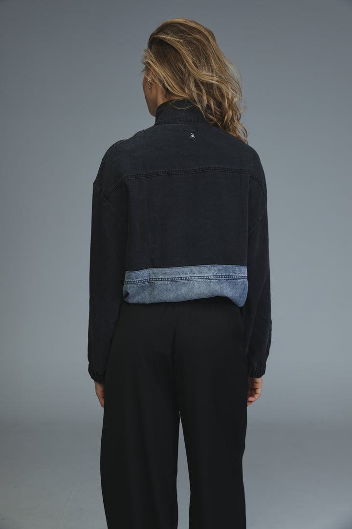Soft denim panel jacket in black with a contrasting light blue denim band across the lower back shown from the back