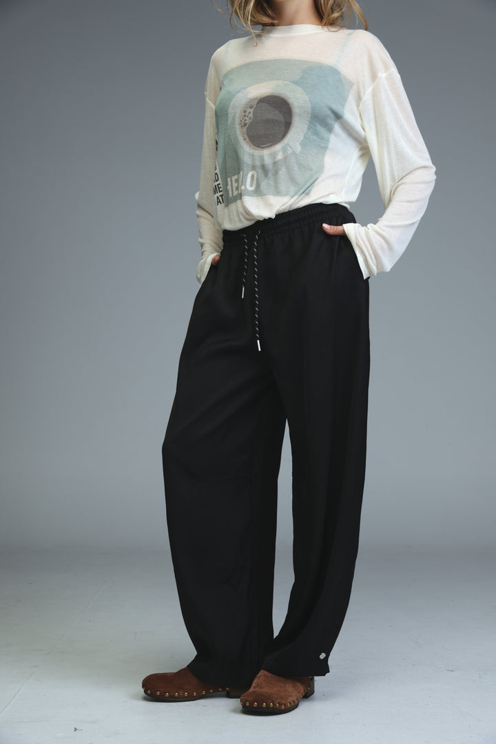 Golden black bottoms featuring black wide-leg pants with a drawstring waist and subtle side pockets shown from the front