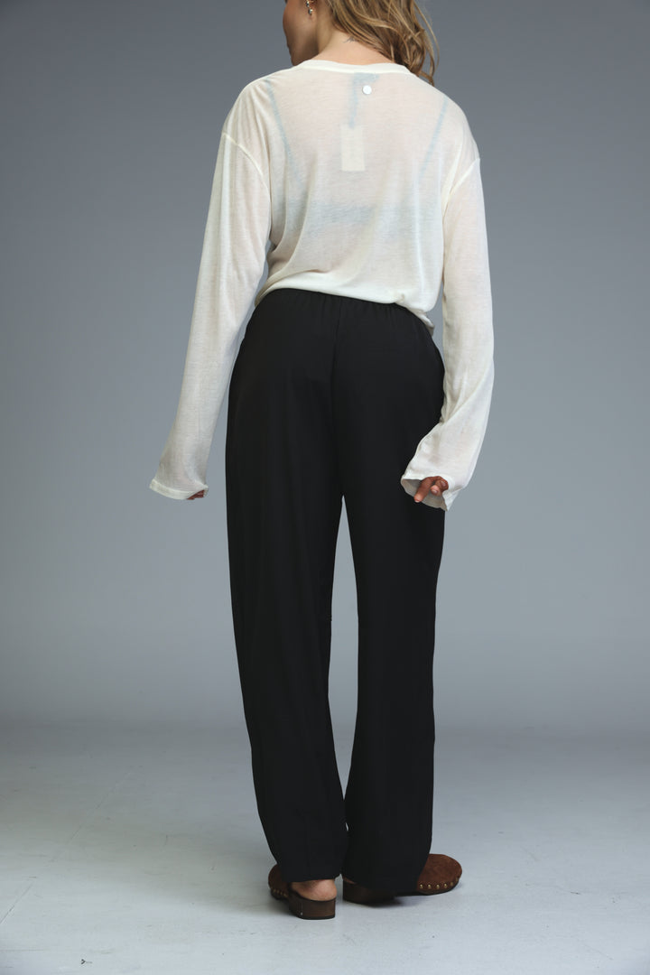 Black wide-leg trousers with subtle vertical seam detailing shown from the front in the golden black bottoms collection