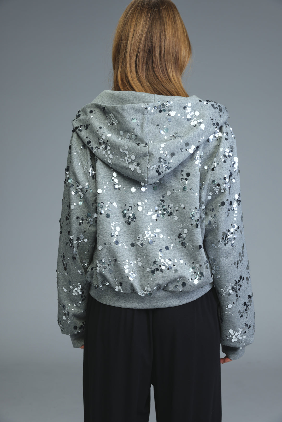 Fortune grey jacket is a silver sequined hoodie with a soft textured fabric and a cozy hood visible from the front