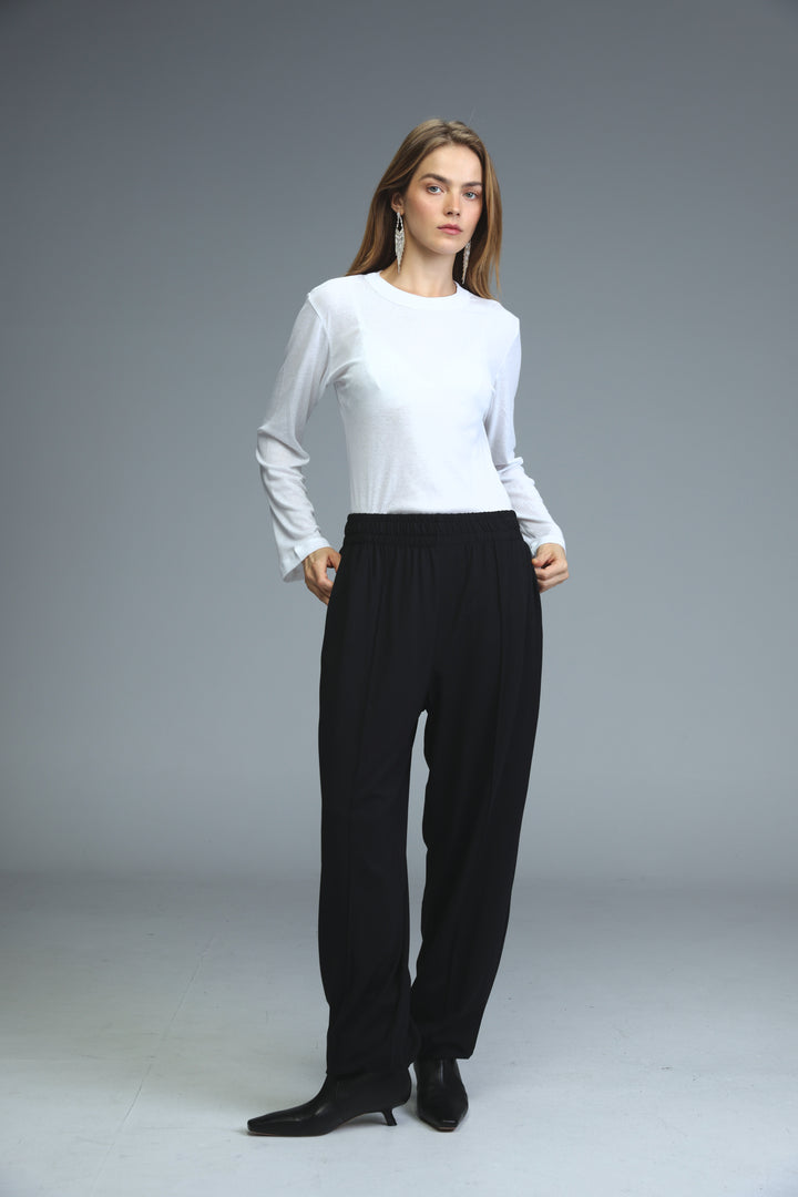White long-sleeved top with round neckline and slightly flared cuffs shown from the front for best black joggers product