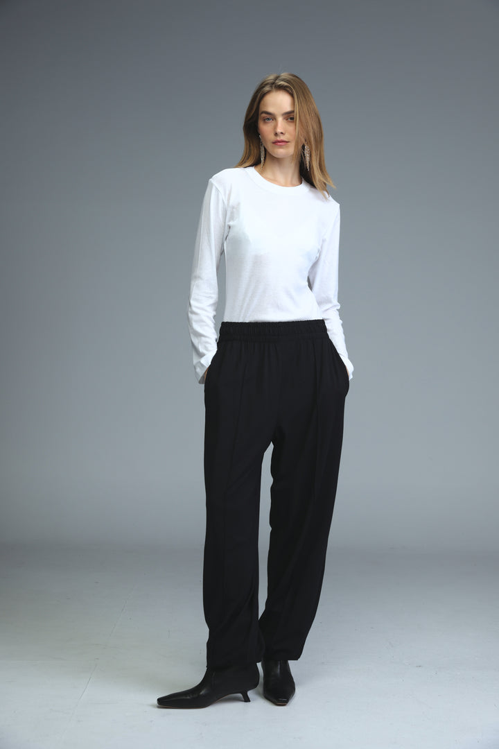 Black high-waisted joggers shown front view paired with a minimalist white long-sleeved top with round neckline