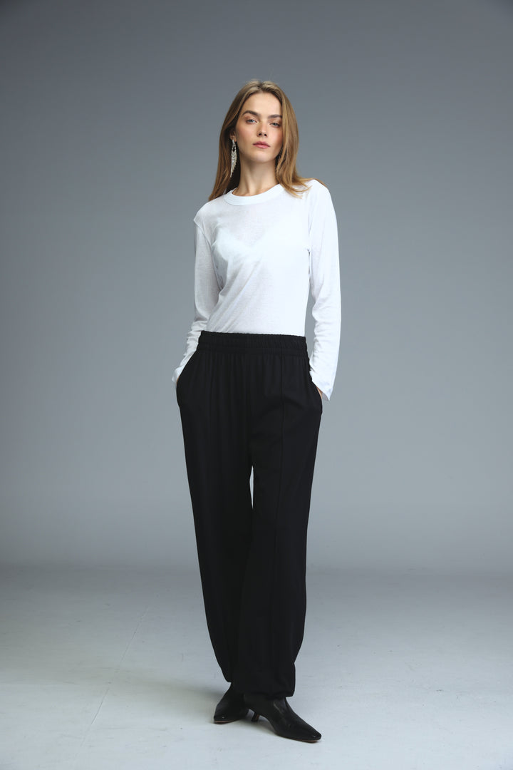 White minimalist long-sleeved top with round neckline and subtle side seam detailing shown from the front