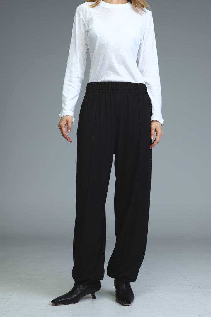 Black high-waisted wide-leg joggers with subtle pleats at the waistband and a flowing fabric front view
