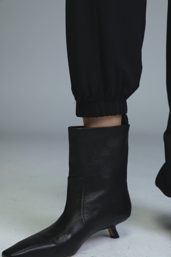 Black leather ankle boot with pointed toe and low kitten heel shown from side view for best black joggers