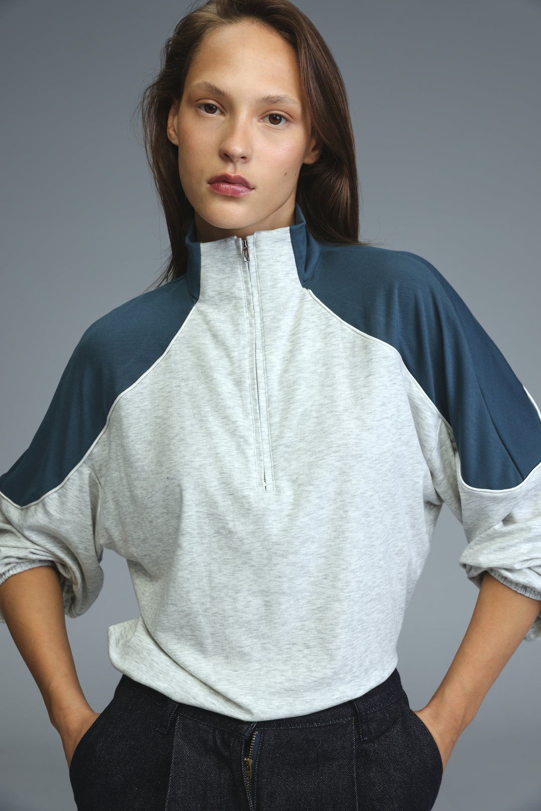 Allure grey sweatshirt with raglan navy blue sleeves and half-zip front in a soft textured fabric visible from the front