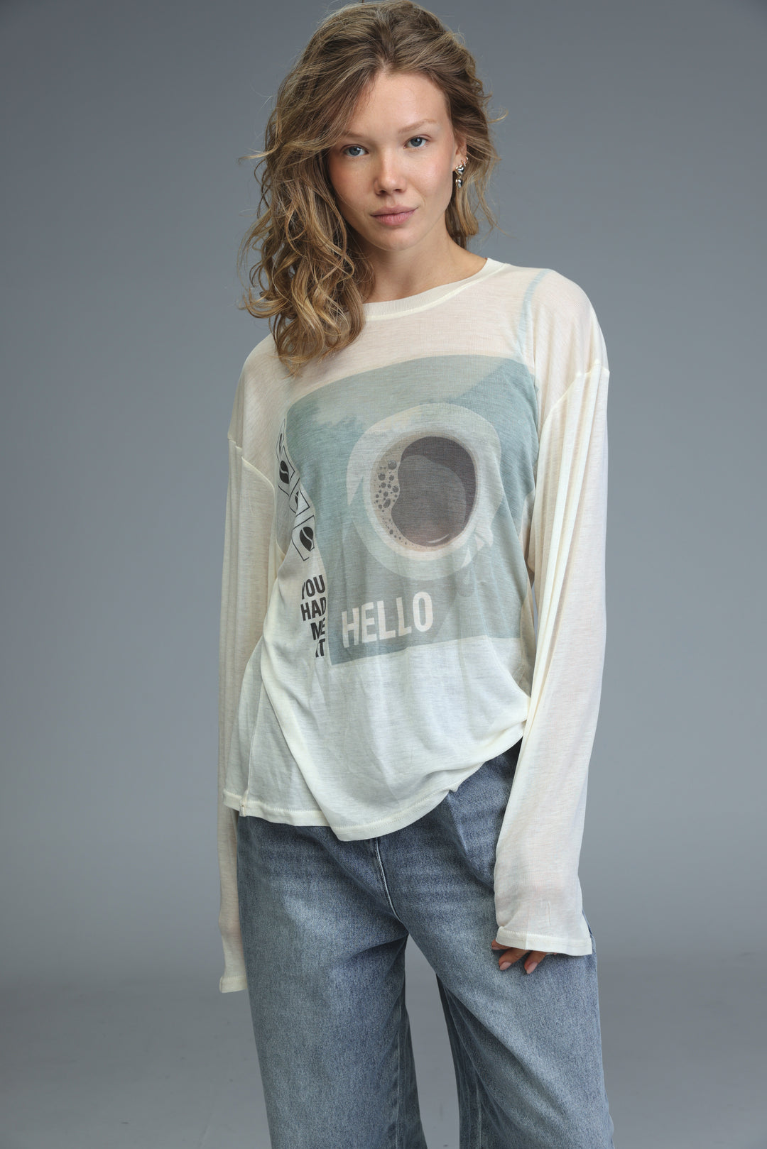 Off-white long-sleeved hello coffee cream shirt with faded mint-green hello graphic and circular design on front