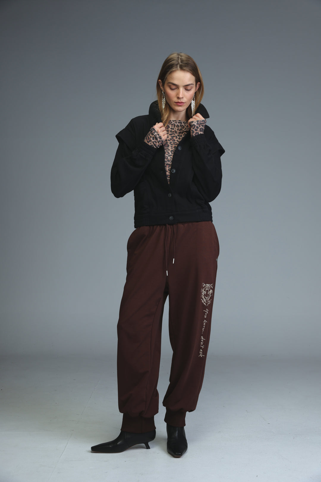 Black faux-fur-lined cardigan with leopard-print cuffs paired with iconic brown joggers visible from front view
