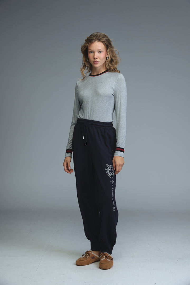 Trim grey bodysuit paired with black jogger pants featuring white tiger embroidery and red and white striped cuffs