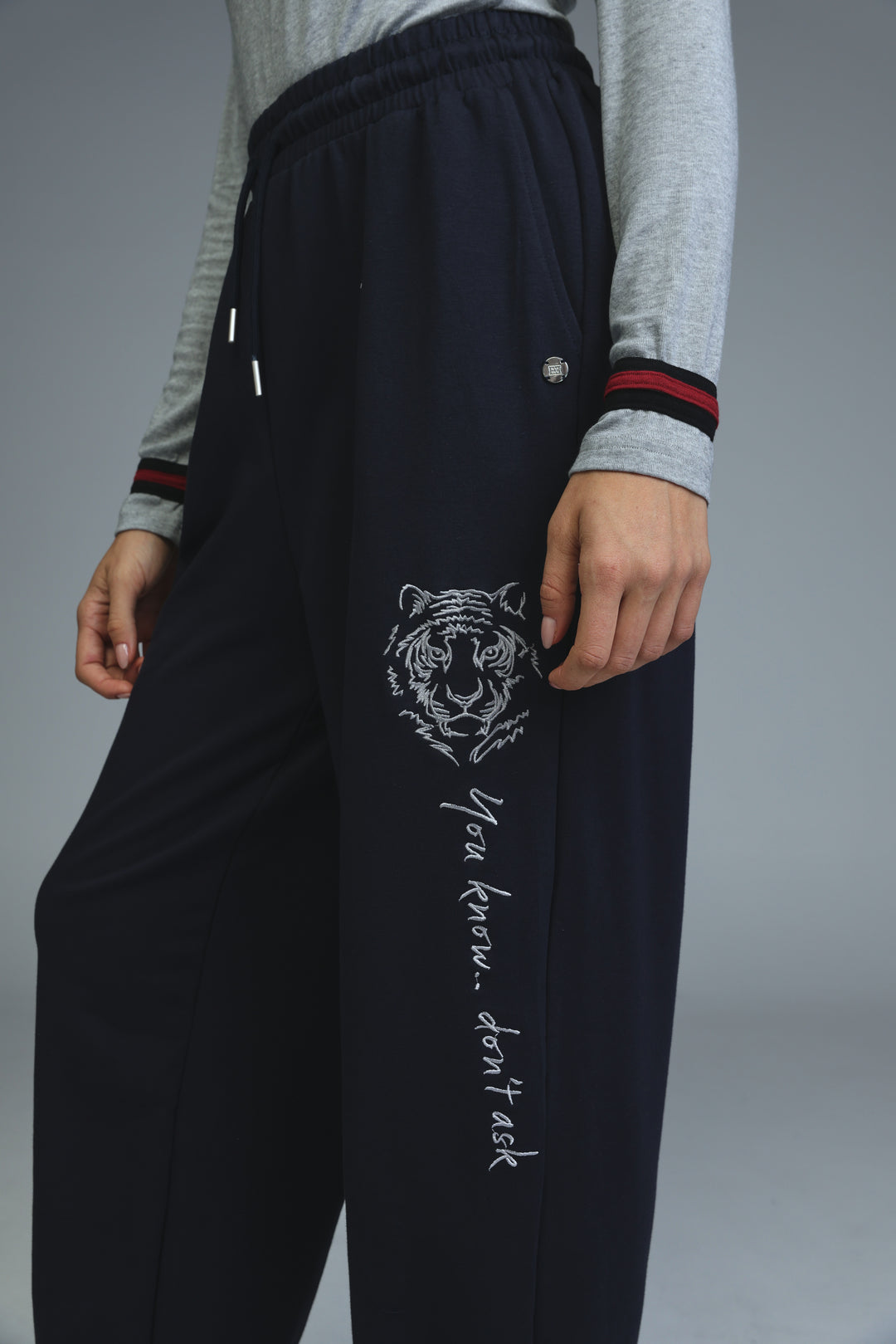 Navy blue tiger-themed joggers with white embroidered design and you know text on the front side