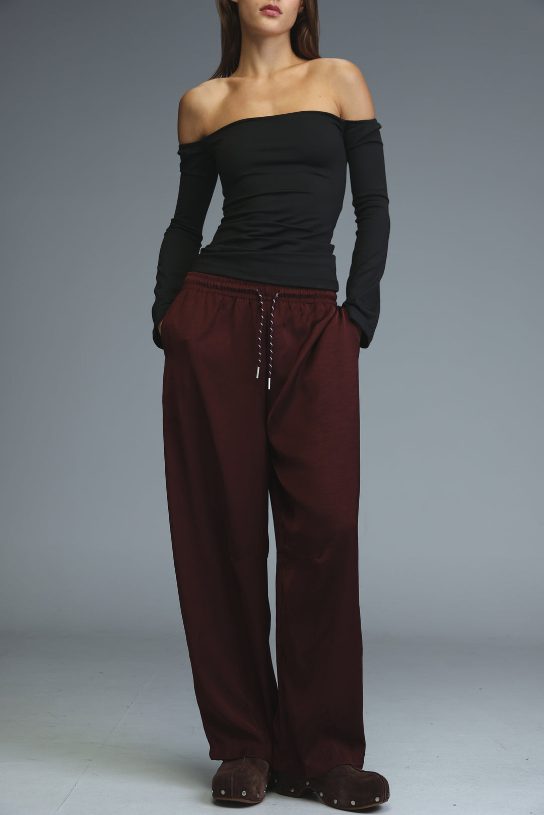 The model wears golden wine wide-leg trousers with an elastic waistband and drawstring closure shown from the front