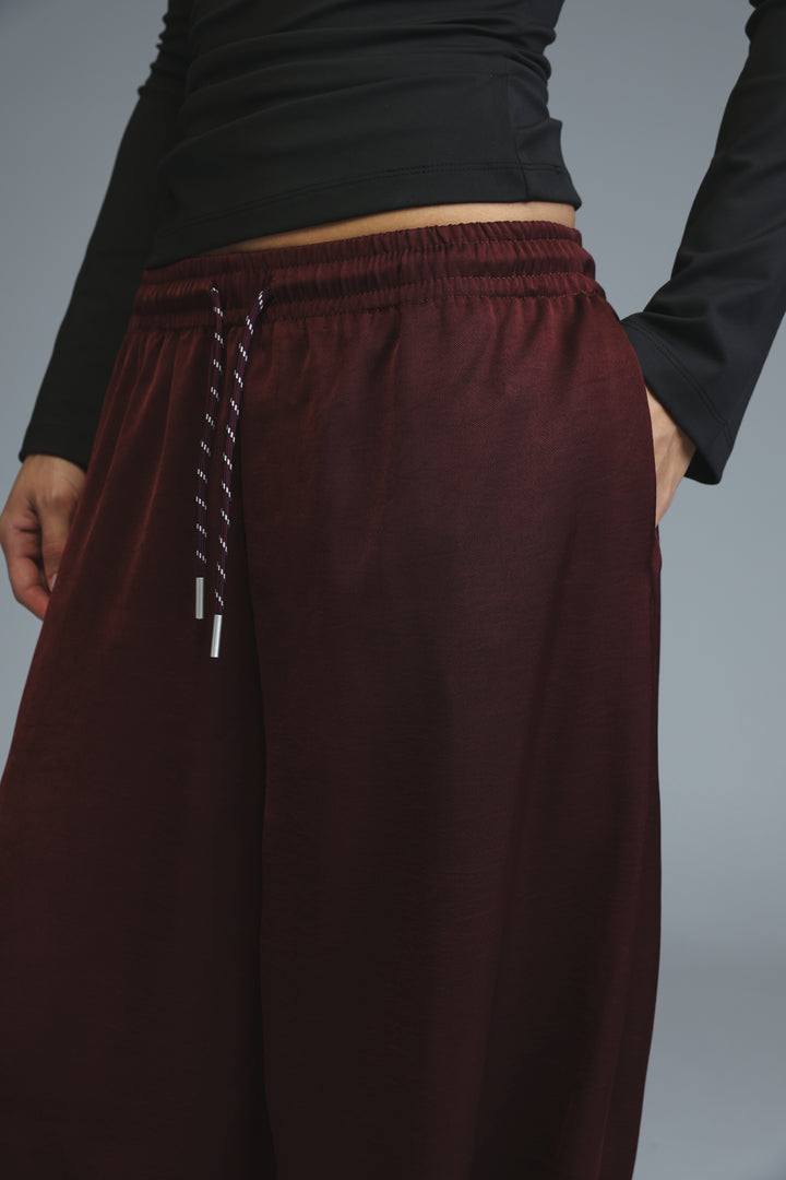 Maroon wide-leg Golden Wine bottoms with a drawstring waistband and silver-toned aglets shown from the front