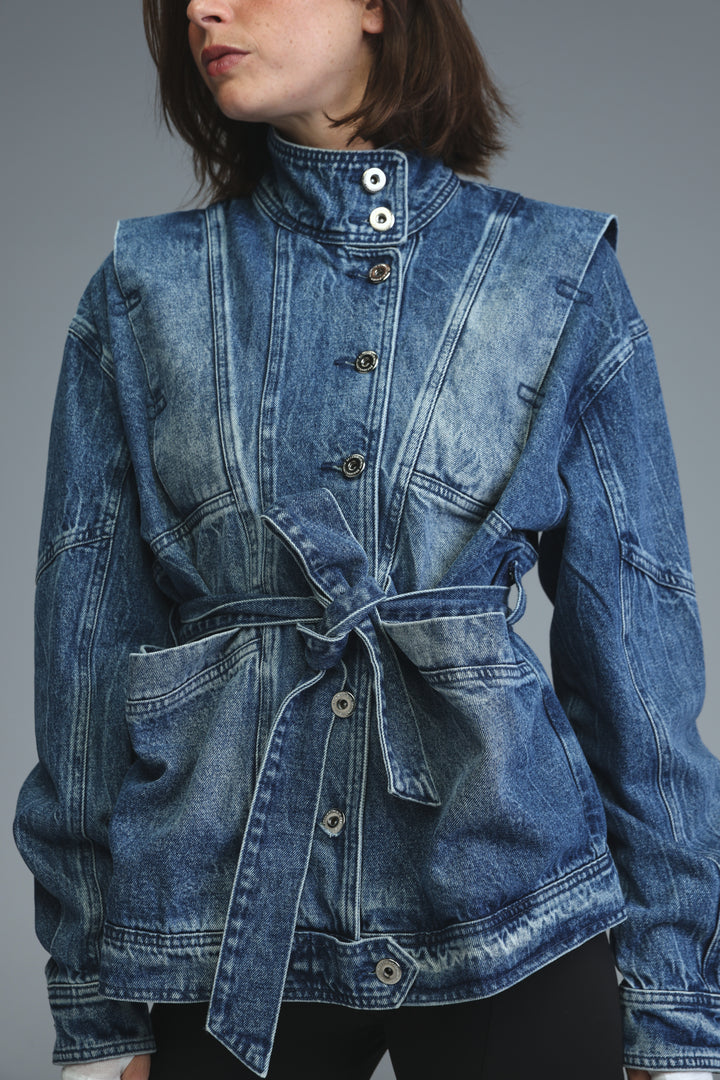Prestige blue denim jacket with high collar, front button closure, and self-tie belt shown from the front