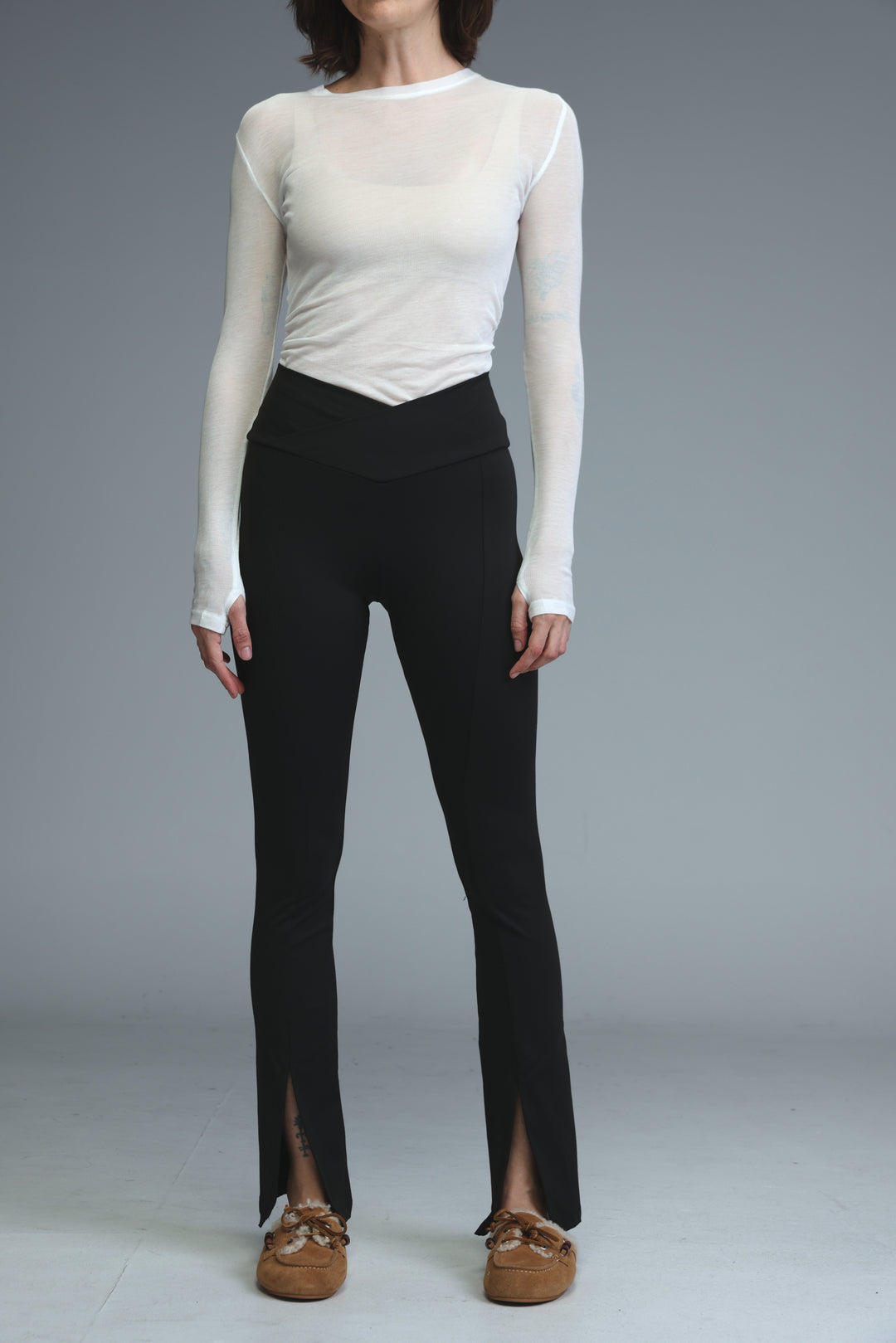 Front slit black leggings with high waist, flare leg, side slit, and elastic waistband shown from the front view