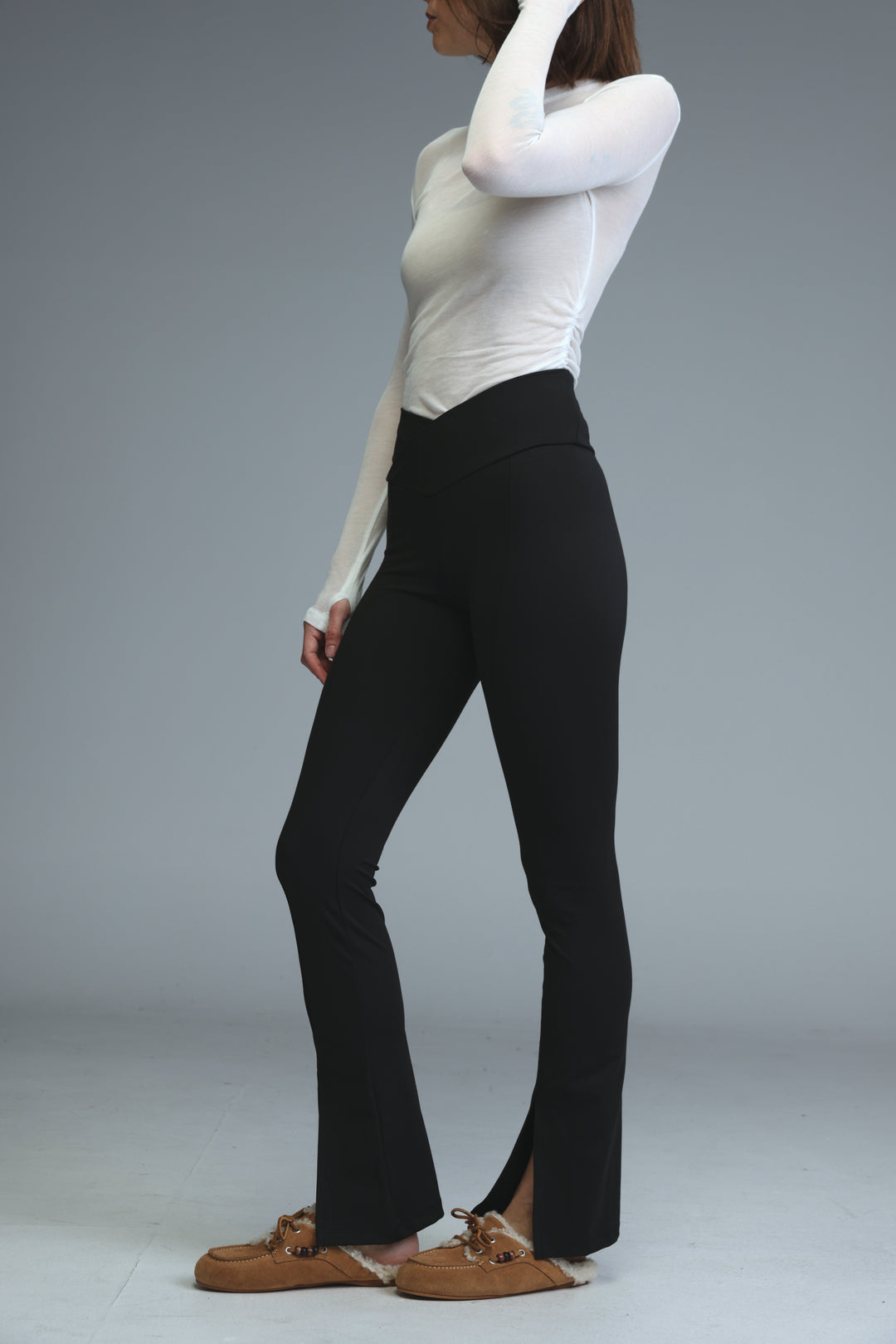 Black high-waisted flared leggings with a front side slit shown from the front view