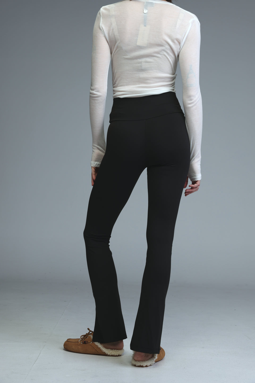 Front slit black leggings shown from the front with high-waisted flared design and smooth form-fitting fabric