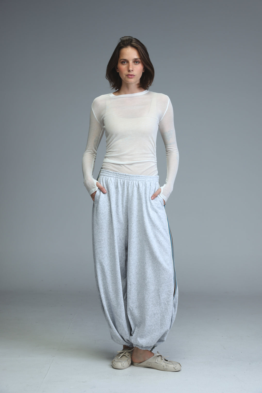 Ballooning grey striped joggers shown from the front with loose fit and subtle textured side stripes