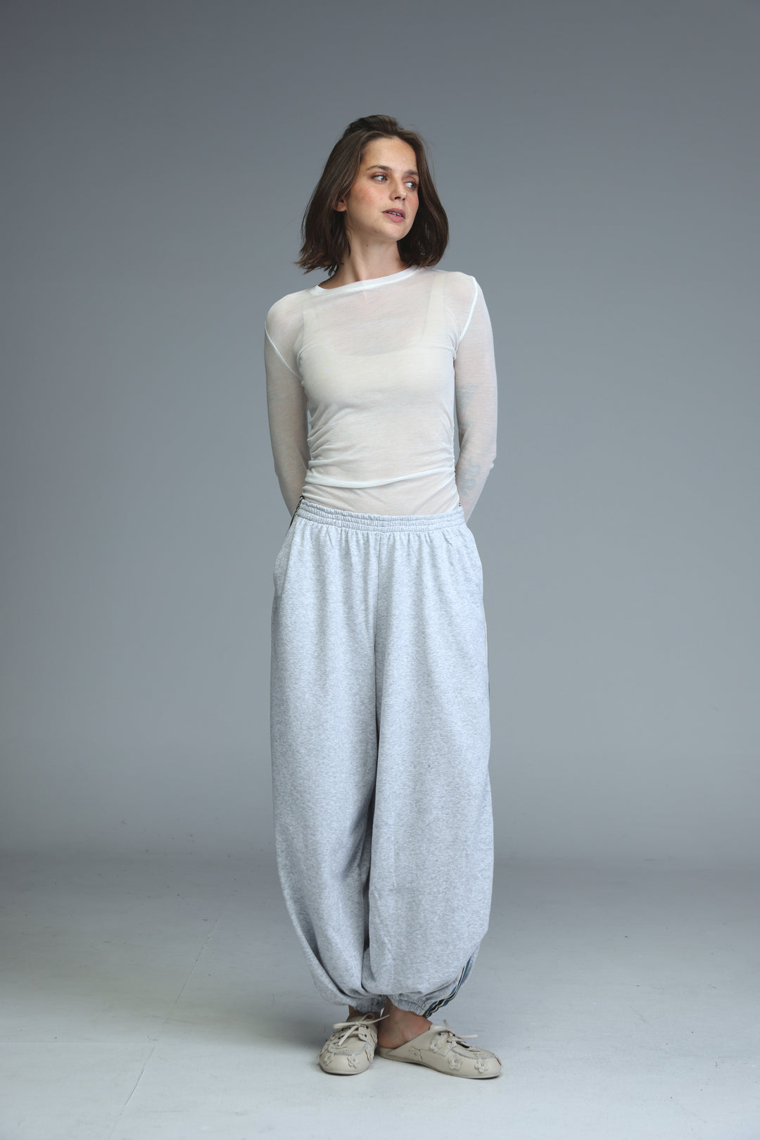 Light blue loose-fitting harem pants with subtle textured pattern and elastic waistband shown from the front