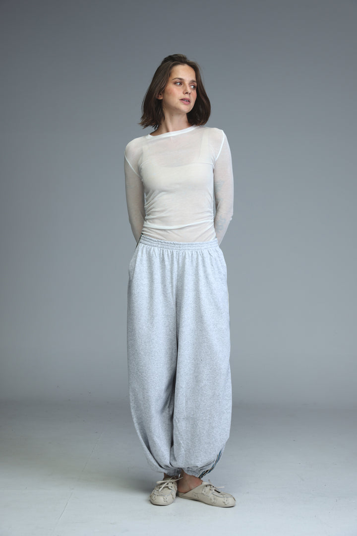 Light blue loose-fitting harem pants with subtle textured pattern and elastic waistband shown from the front