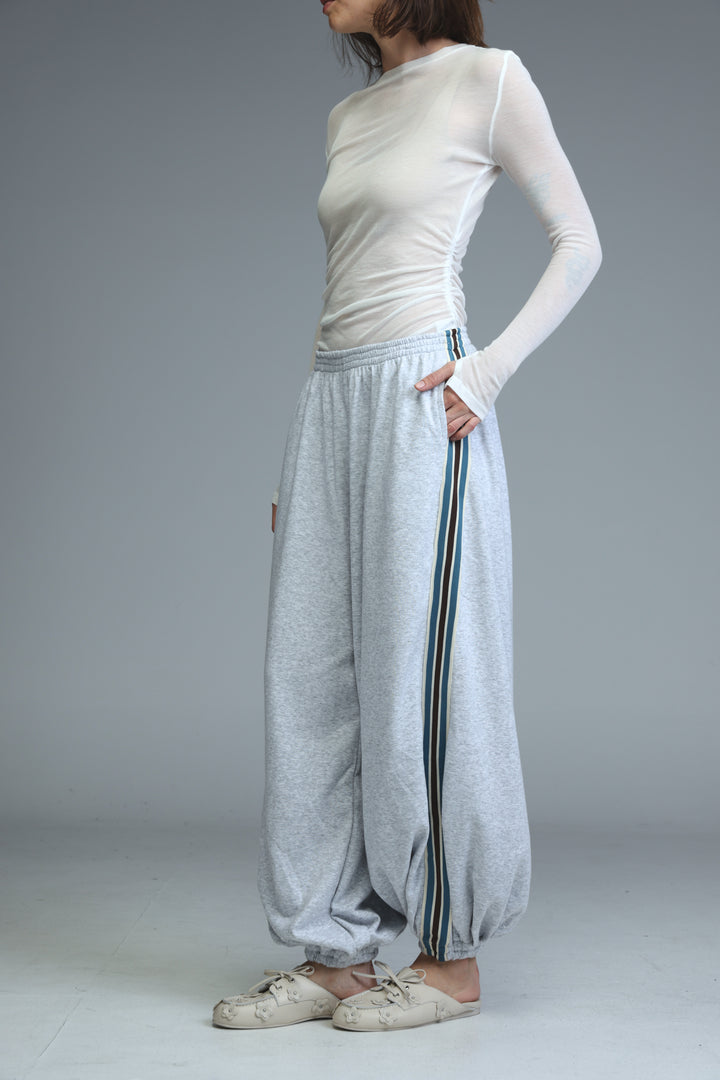 Ballooning grey striped joggers shown front view with loose fit and vertical striped side panels