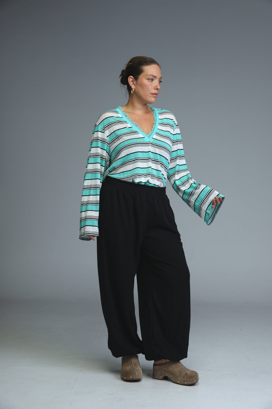 A glow grey striped shirt with teal and white stripes and a v-neckline shown from the front
