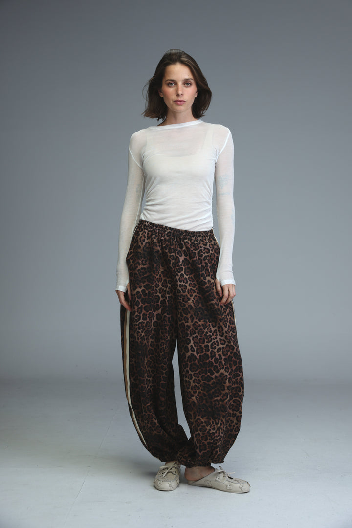 Brown leopard-print wide-leg ballooning joggers with a white side stripe shown from the front