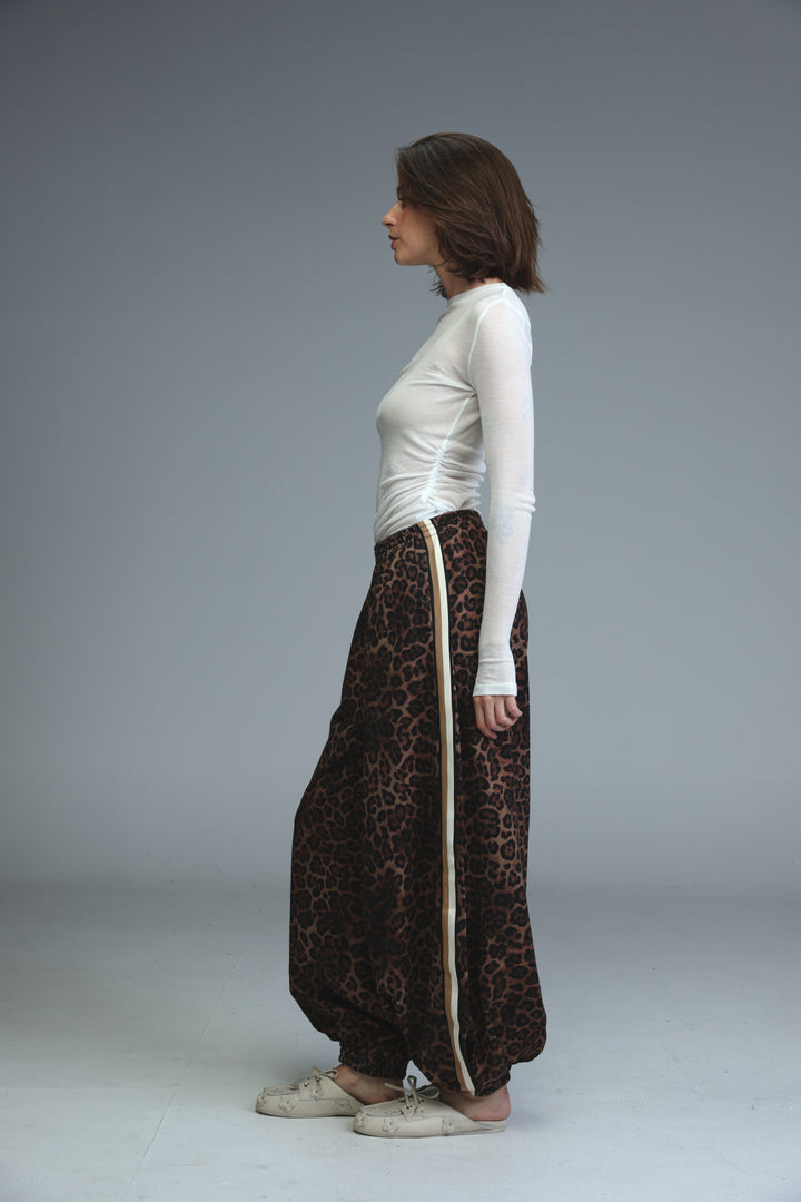 Brown leopard-print wide-leg joggers with beige vertical stripe down the side shown from the front