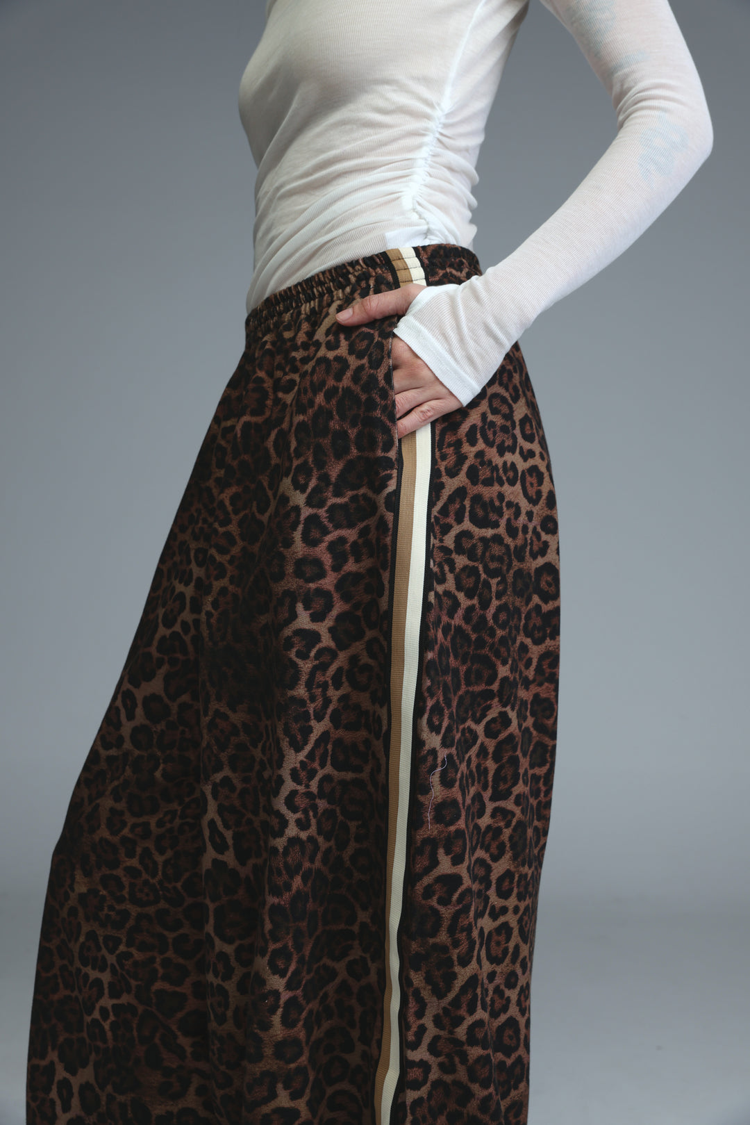 Ballooning leopard striped joggers with beige vertical stripe side detail worn over white long sleeved top front view
