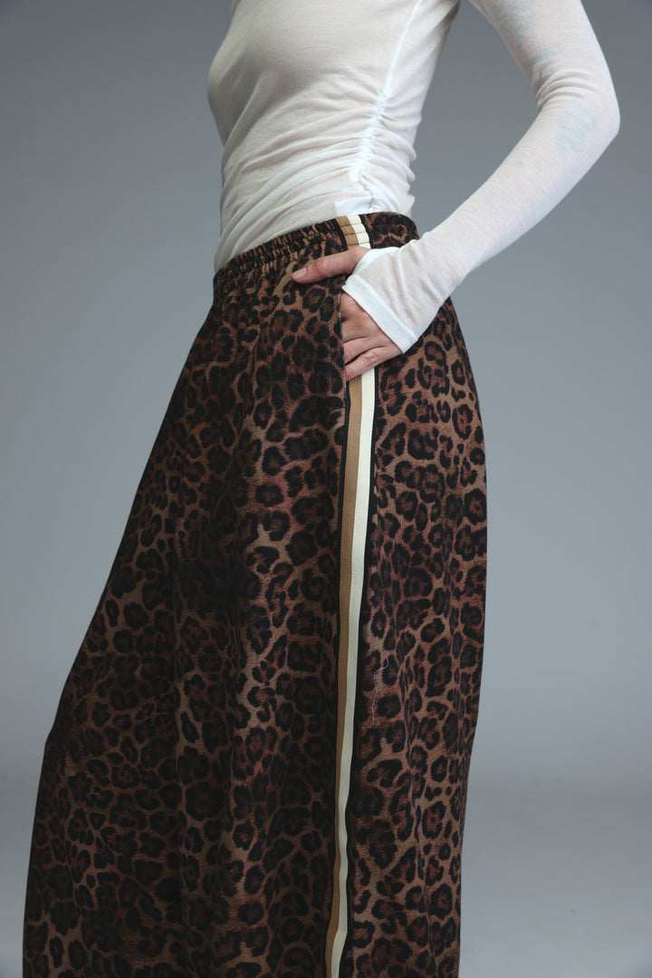 Ballooning leopard striped joggers with beige vertical stripe side detail worn over white long sleeved top front view