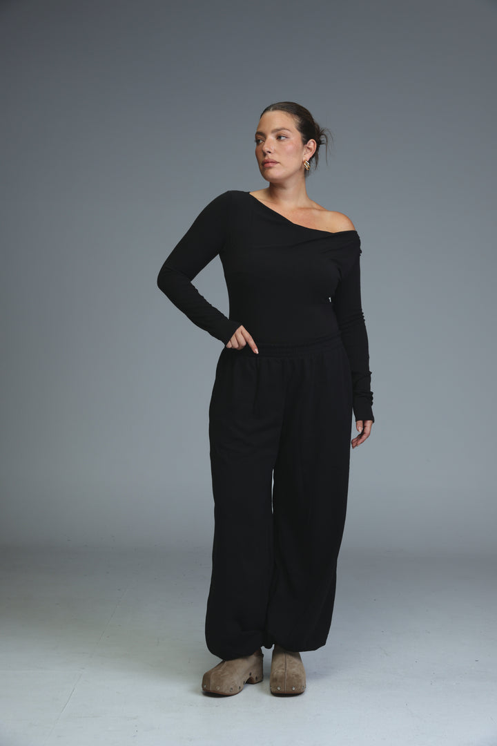 Black one-shoulder long-sleeved jumpsuit with wide-leg pants shown from the front in a miss black shirt collection